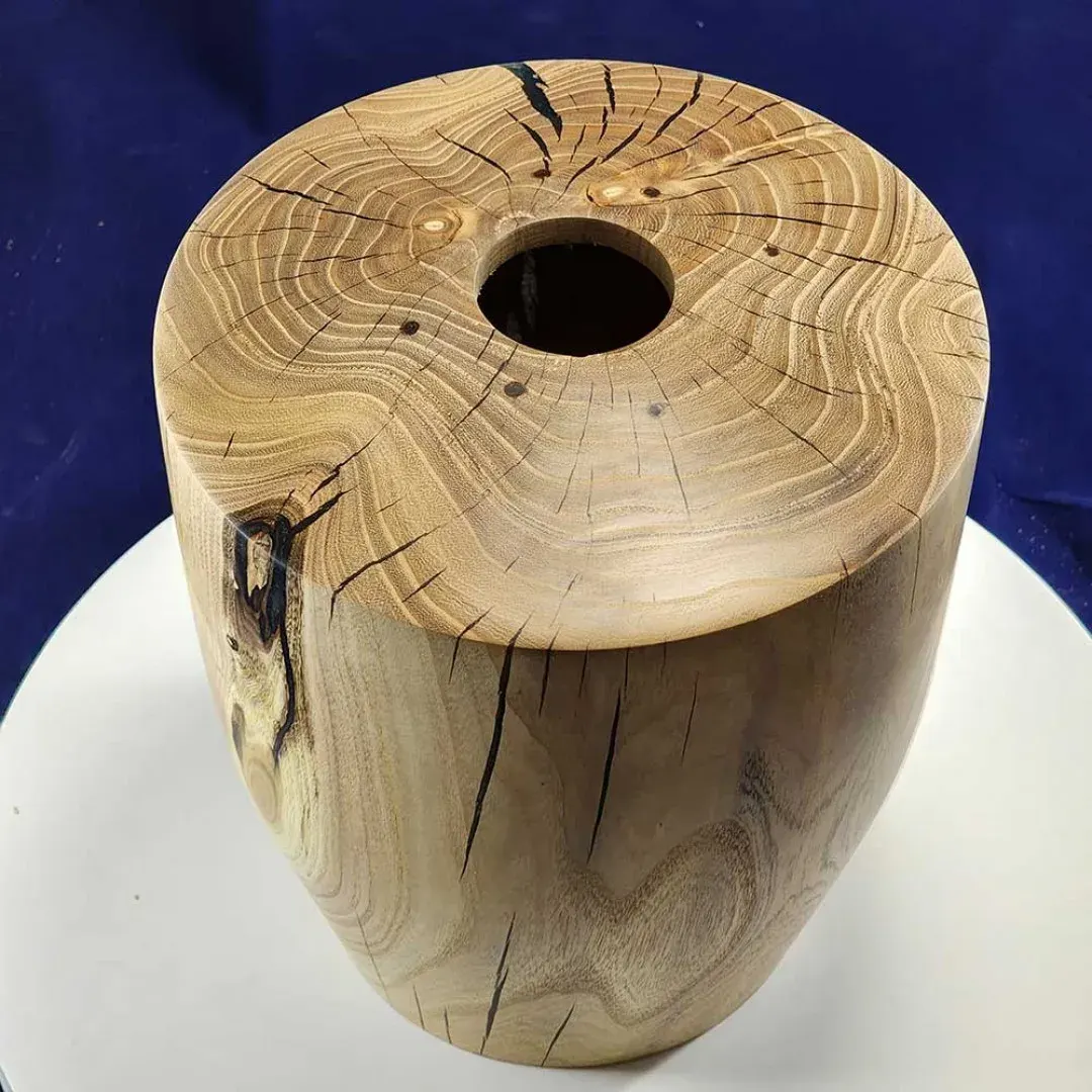 Ash urn turned by Don Roden — top-down view showing spalting and natural grain on a dark navy backdrop.